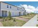 Exterior view of townhomes with brick driveways, landscaping, and light-colored exteriors at 16399 Bird Of Paradise Ave, Clermont, FL 34714