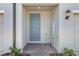 Charming light blue front door with brick landing, and modern wall lantern at 16399 Bird Of Paradise Ave, Clermont, FL 34714