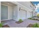 View of the property featuring the one car garage, light blue door and brick driveway at 16399 Bird Of Paradise Ave, Clermont, FL 34714