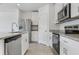 This well-appointed kitchen includes stainless-steel appliances, sleek white cabinetry, and granite countertops at 16399 Bird Of Paradise Ave, Clermont, FL 34714