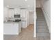 Well-lit kitchen features new stainless-steel appliances, white cabinets, and a staircase leading to the second floor at 16399 Bird Of Paradise Ave, Clermont, FL 34714