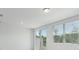 The light-filled living area features sliding glass doors to the backyard and a window with nature views at 16399 Bird Of Paradise Ave, Clermont, FL 34714