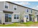 Rear exterior of a modern, two-story home with a grassy backyard and a sliding glass door at 16466 Bird Of Paradise Ave, Clermont, FL 34714