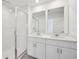 Modern bathroom features a double sink vanity, quartz countertop, and glass enclosed shower at 16466 Bird Of Paradise Ave, Clermont, FL 34714