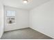 Well-lit bedroom with neutral carpet, white walls, and a window with neighborhood views at 16466 Bird Of Paradise Ave, Clermont, FL 34714
