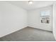 Bright bedroom featuring neutral carpeting, white walls, and a window showcasing the neighborhood at 16466 Bird Of Paradise Ave, Clermont, FL 34714