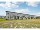 The exterior of a neighborhood of newly built two story townhomes with young landscaping at 16466 Bird Of Paradise Ave, Clermont, FL 34714