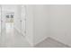 Hallway with light flooring and white walls, leading to various rooms at 16466 Bird Of Paradise Ave, Clermont, FL 34714