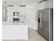 Contemporary kitchen boasting white cabinets, a center island, and modern appliances at 16466 Bird Of Paradise Ave, Clermont, FL 34714