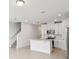 Open-concept kitchen with white cabinets, stainless steel appliances, and tiled flooring at 16466 Bird Of Paradise Ave, Clermont, FL 34714