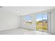Bright, open living area with sliding glass doors to the outside, showcasing tile flooring at 16466 Bird Of Paradise Ave, Clermont, FL 34714