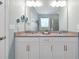 Bright bathroom featuring double sinks, stone countertops, a linen closet and a glass enclosed shower at 16527 Sea Glass St, Winter Garden, FL 34787