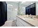 Well-lit bathroom with double sink vanity, framed mirror, and a shower with dark blue shower curtain at 16527 Sea Glass St, Winter Garden, FL 34787