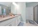 Bright bathroom featuring a double vanity with stone countertops and a glass-enclosed shower at 16527 Sea Glass St, Winter Garden, FL 34787