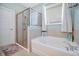 Bright bathroom featuring a soaking tub, glass-enclosed shower, and a window with privacy blinds at 16527 Sea Glass St, Winter Garden, FL 34787