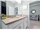 Bright bathroom featuring a double vanity sink, decorative shelving, and tiled flooring at 16527 Sea Glass St, Winter Garden, FL 34787