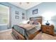 Bedroom featuring a wooden bed frame with storage drawers and blue walls adorned with artwork at 16527 Sea Glass St, Winter Garden, FL 34787