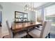 Elegant dining room with a large wooden table, upholstered chairs, and modern lighting fixture at 16527 Sea Glass St, Winter Garden, FL 34787