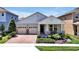 Charming single-Gathering home featuring a brick driveway, manicured lawn, and covered front porch at 16527 Sea Glass St, Winter Garden, FL 34787