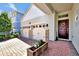 Attractive home exterior with a two-car garage, brick driveway, and a red front door adorned with a floral wreath at 16527 Sea Glass St, Winter Garden, FL 34787