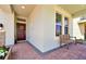 Covered front porch featuring a wooden bench, brick flooring, and a decorative wreath on the front door for a cozy entrance at 16527 Sea Glass St, Winter Garden, FL 34787