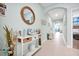Bright hallway with neutral tile flooring, decorative mirror, console table, and recessed lighting creating an inviting entrance at 16527 Sea Glass St, Winter Garden, FL 34787