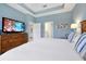 Spacious main bedroom with a king bed, tray ceiling, TV, and ensuite bathroom and walk-in closet at 16527 Sea Glass St, Winter Garden, FL 34787