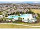 Aerial view of a resort-style pool and clubhouse with palm trees and ample lounge seating for residents' enjoyment at 16527 Sea Glass St, Winter Garden, FL 34787