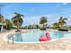 Resort-style pool with palm trees, lounge chairs, and a pink flamingo float offering a relaxing oasis at 16527 Sea Glass St, Winter Garden, FL 34787