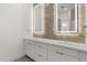 Modern bathroom with double vanity, illuminated mirrors and neutral toned textured tile backsplash at 1768 Mondrian Cir, Winter Park, FL 32789