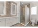 Bathroom featuring dual sinks, illuminated mirrors, gray tiled accent wall and a glass enclosed shower at 1768 Mondrian Cir, Winter Park, FL 32789