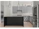 Stylish kitchen showcasing gray cabinets, black countertops, and hardwood floors at 1768 Mondrian Cir, Winter Park, FL 32789