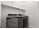 Modern laundry room featuring a front-load washer and dryer, and white cabinets for storage at 1768 Mondrian Cir, Winter Park, FL 32789