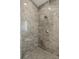 Close up of walk-in shower featuring rain shower head, wall mounted shower head, and gray penny tile floor at 1768 Mondrian Cir, Winter Park, FL 32789