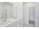 Bright bathroom boasting dual sinks, white cabinetry, and a glass-enclosed shower at 1801 Archer Dr, Minneola, FL 34715