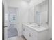 Bright bathroom featuring double sinks, white cabinets, and large mirrors for a modern feel at 1801 Archer Dr, Minneola, FL 34715