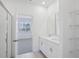 Light-filled bathroom with dual sinks, a shower with glass door, and a walk-in closet at 1801 Archer Dr, Minneola, FL 34715