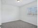 This bedroom boasts a window bringing in natural light and neutral carpet at 1801 Archer Dr, Minneola, FL 34715
