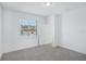 Simple carpeted bedroom featuring a door to the hallway and a bright window at 1801 Archer Dr, Minneola, FL 34715