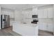 Bright kitchen featuring white cabinetry, stainless steel appliances, and a large island at 1801 Archer Dr, Minneola, FL 34715