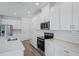 Contemporary kitchen with white cabinets, stainless steel appliances, and stylish backsplash at 1801 Archer Dr, Minneola, FL 34715