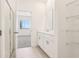 Bright bathroom featuring a glass-enclosed shower, double vanity, and open closet space at 1812 Archer Dr, Minneola, FL 34715