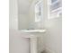 Pedestal sink and mirror in a bright and clean half bathroom with neutral tones at 1812 Archer Dr, Minneola, FL 34715