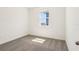 Well-lit bedroom showcasing neutral carpet, white walls, and a street view window at 1812 Archer Dr, Minneola, FL 34715