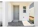 Inviting front door entrance featuring a tiled porch and white columns, with a gray door at 1812 Archer Dr, Minneola, FL 34715