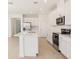 This spacious kitchen features an eat-in island with white cabinetry, stainless appliances, and tiled floors at 1812 Archer Dr, Minneola, FL 34715