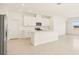 This kitchen offers an eat-in island with white cabinetry, stainless appliances, and tiled floors at 1812 Archer Dr, Minneola, FL 34715