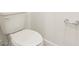 Close-up view of a white toilet and paper holder against a white wall with base trim at 1812 Archer Dr, Minneola, FL 34715