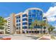 Exterior shot of a modern building with curved blue glass accents, and palm trees at 1845 Delaney Ave, Orlando, FL 32806