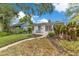 Charming home featuring a curved walkway to the front door, mature landscaping, and a brick facade at 1845 Delaney Ave, Orlando, FL 32806